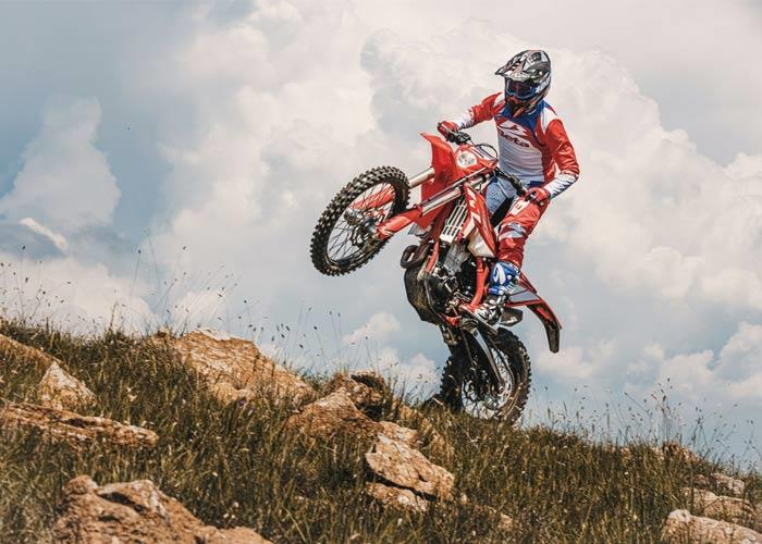 Adult riding a Beta Enduro bike off road.